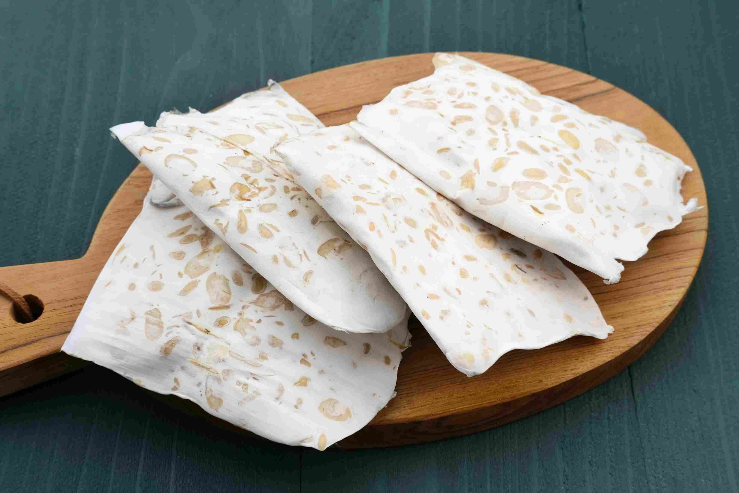 Tempeh isečen na komade na drvenoj dasci, kao biljni izvor proteina