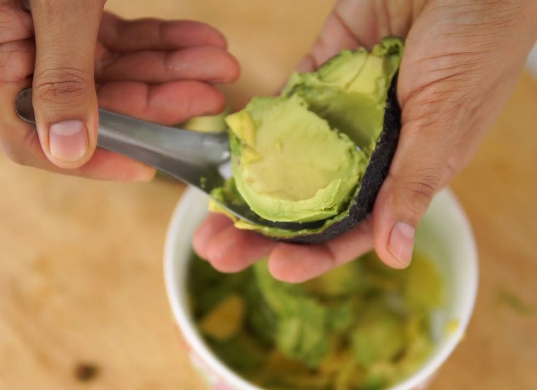 osoba čisti avokado