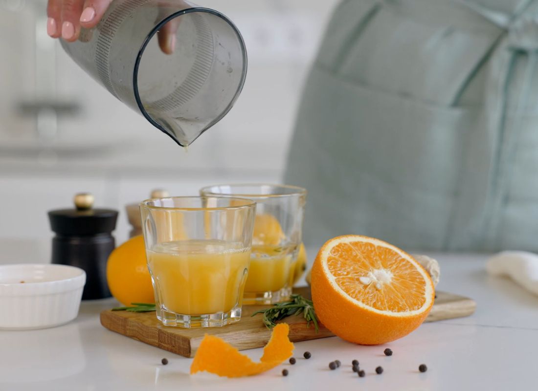 osoba sipa sok od pomorandže u čaše