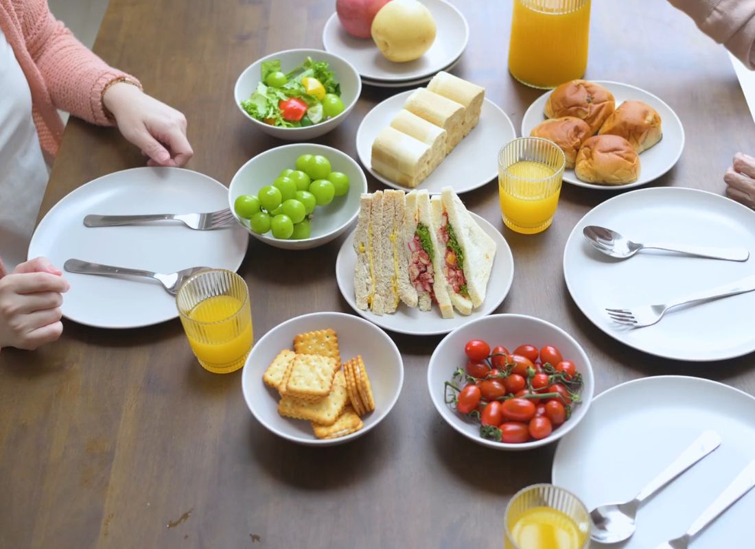 dve osobe sede za stolom na kom je postavljena veganska i vegetarijanska hrana