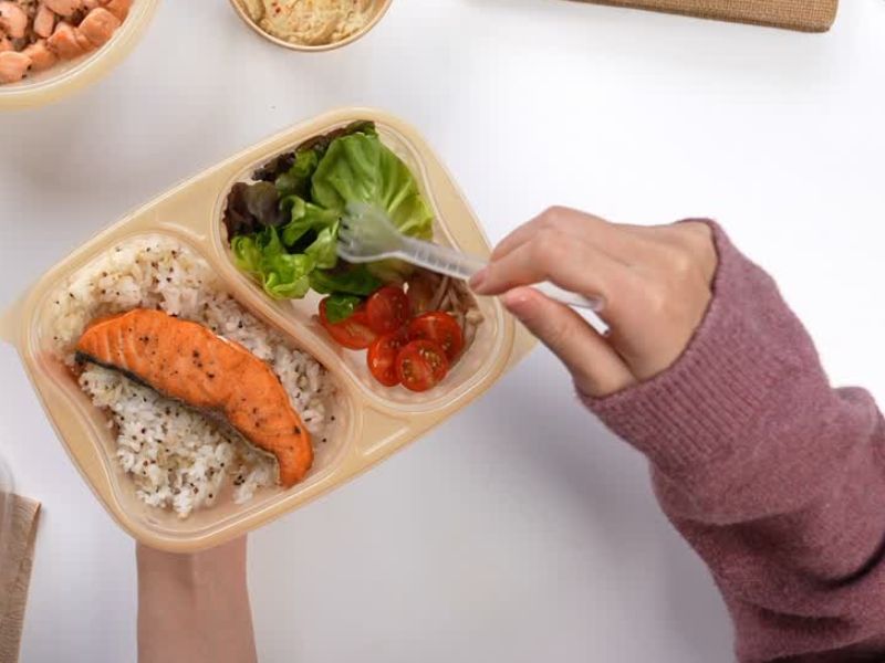 devojka jede salatu, pirinač i lososa