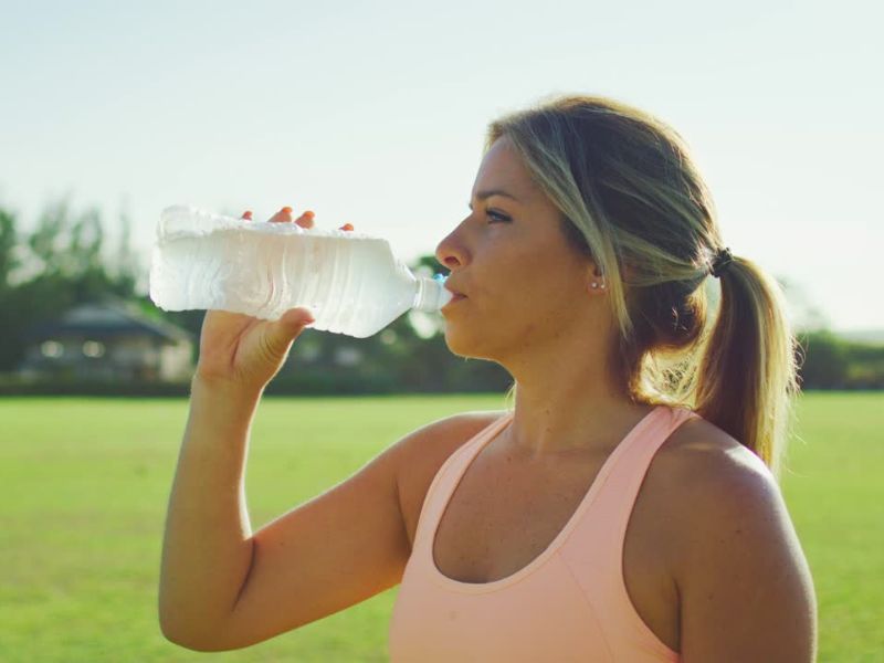devojka pije vodu iz flašice