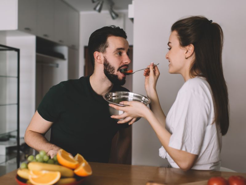 devojka hrani momka zdravom salatom