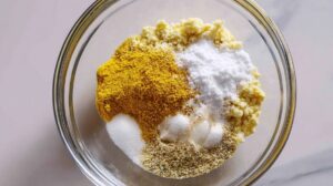 Mix of mustard powder, salt, garlic powder, and honey in a glass bowl