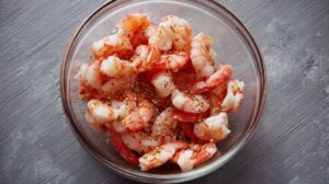 Bowl of chopped cooked shrimp seasoned with herbs and spices