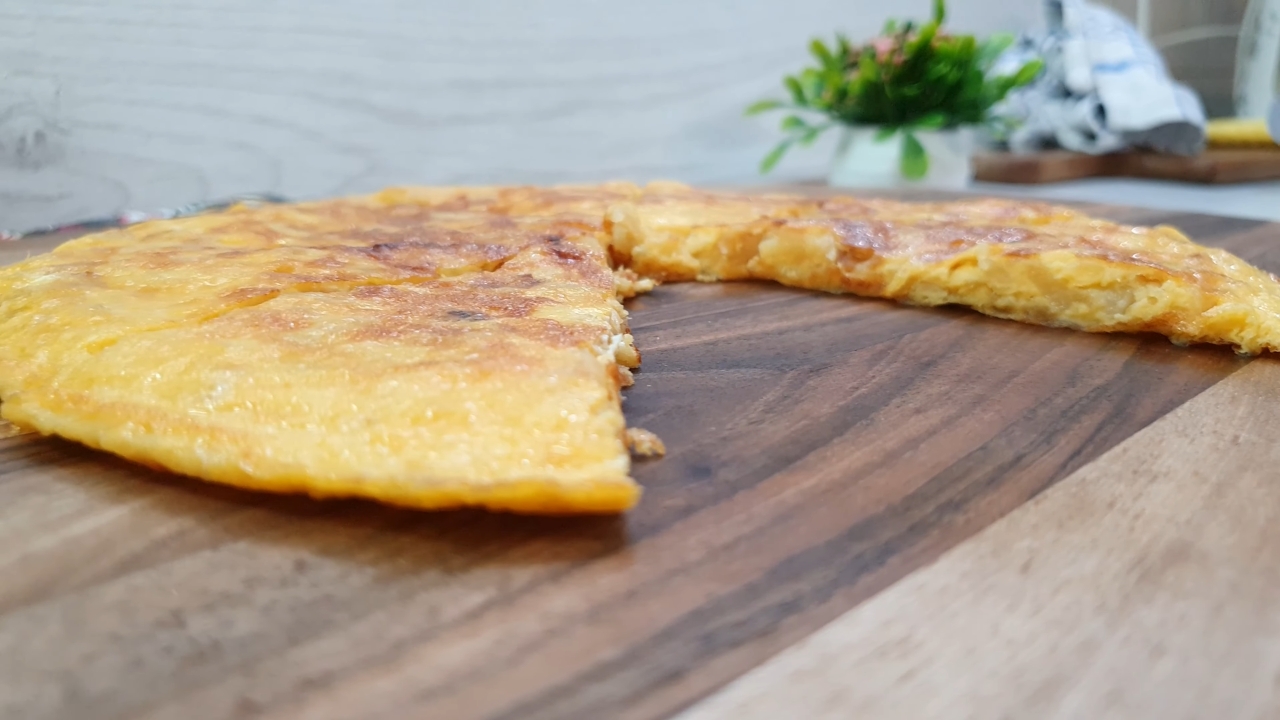 Zlatno pečen omlet isečen na komade, serviran na drvenoj dasci