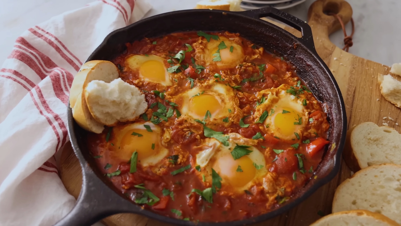 Shakshuka sa jajima u sosu od paradajza i paprike, servirana u tiganju uz hleb