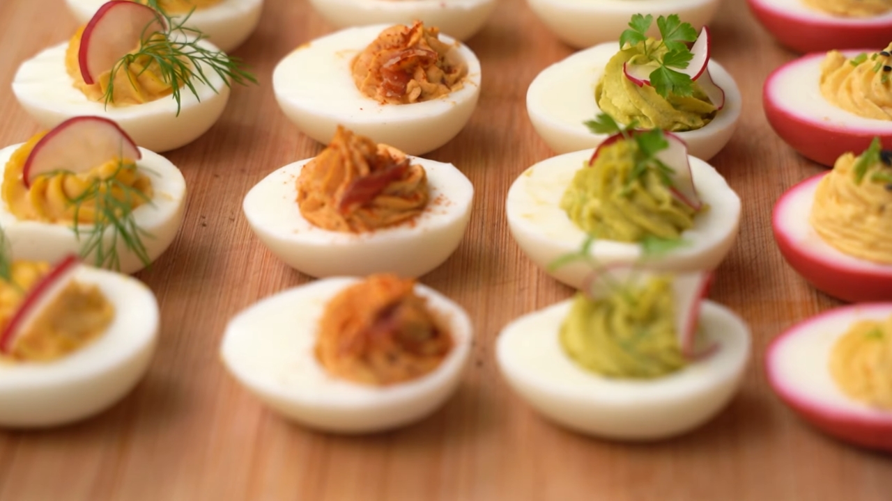 Punjena jaja sa različitim filovima i dekoracijama poređana na drvenoj dasci