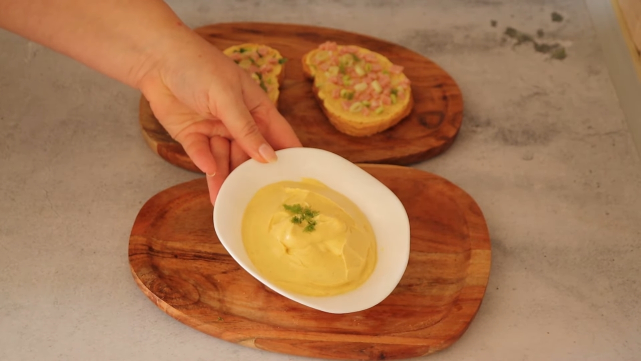 Kremasti namaz od kuvanih jaja serviran u činiji uz hleb na drvenoj dasci