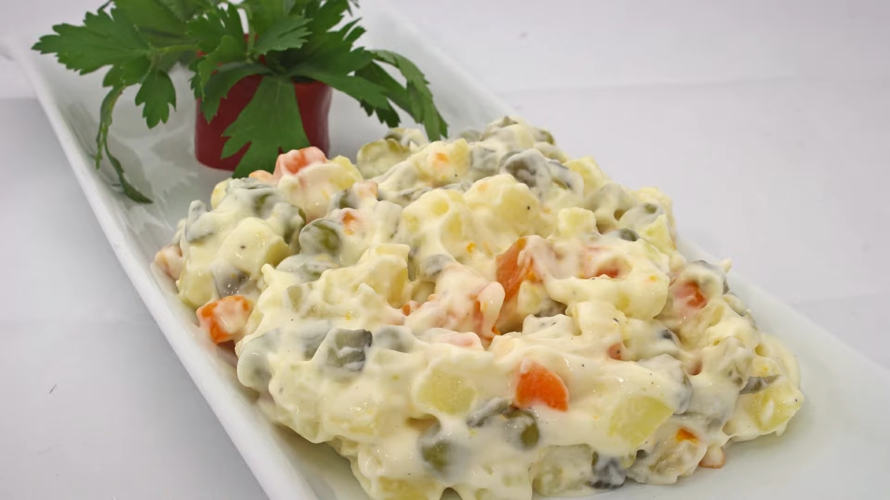 Ruska salata sa jajima, krompirom i povrćem u kremastom prelivu servirana na tanjiru