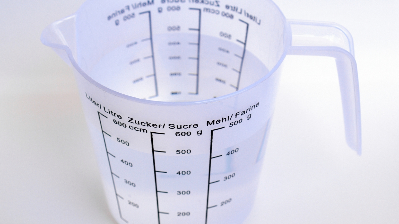 Plastic measuring jug with printed marks for liquid and dry ingredients
