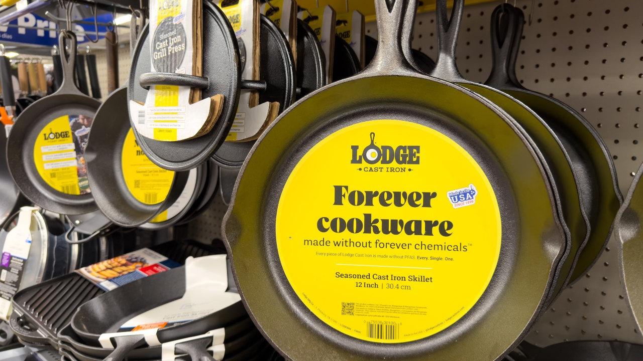 Lodge cast iron skillets hang on a store display with yellow product labels