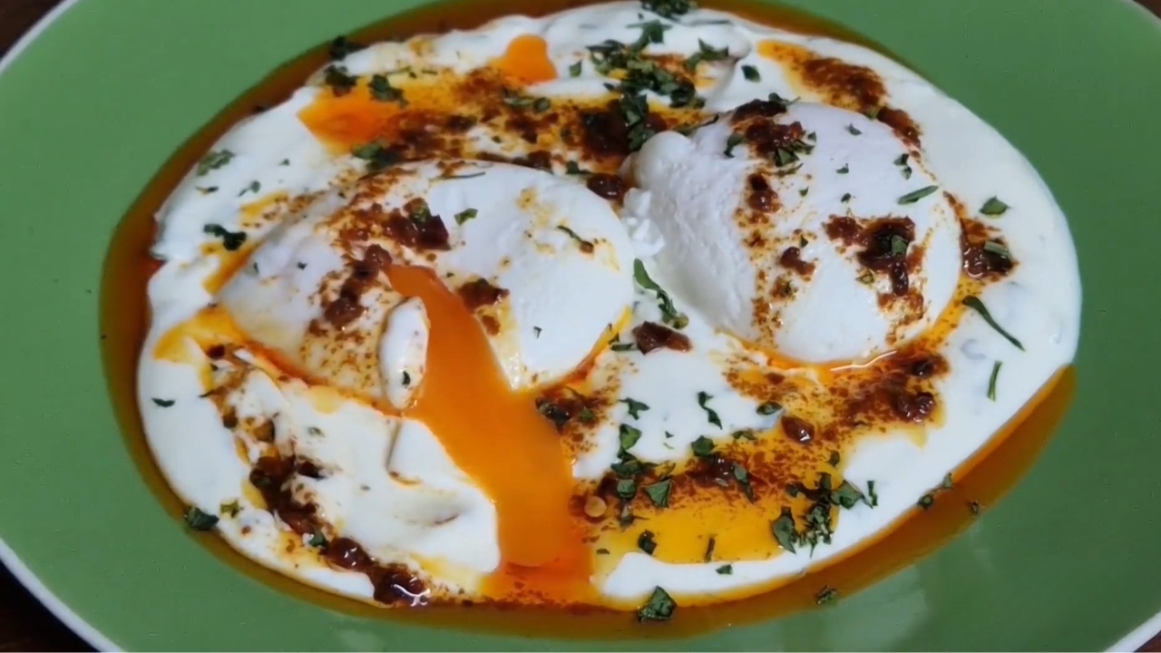 Turkish eggs with runny yolks, garlicky yogurt, chili butter, and chopped herbs.