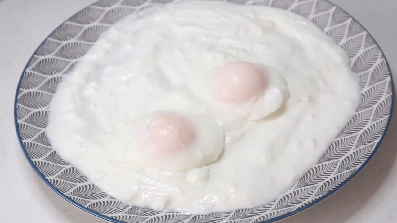 Two poached eggs served over thick yogurt for Turkish eggs.
