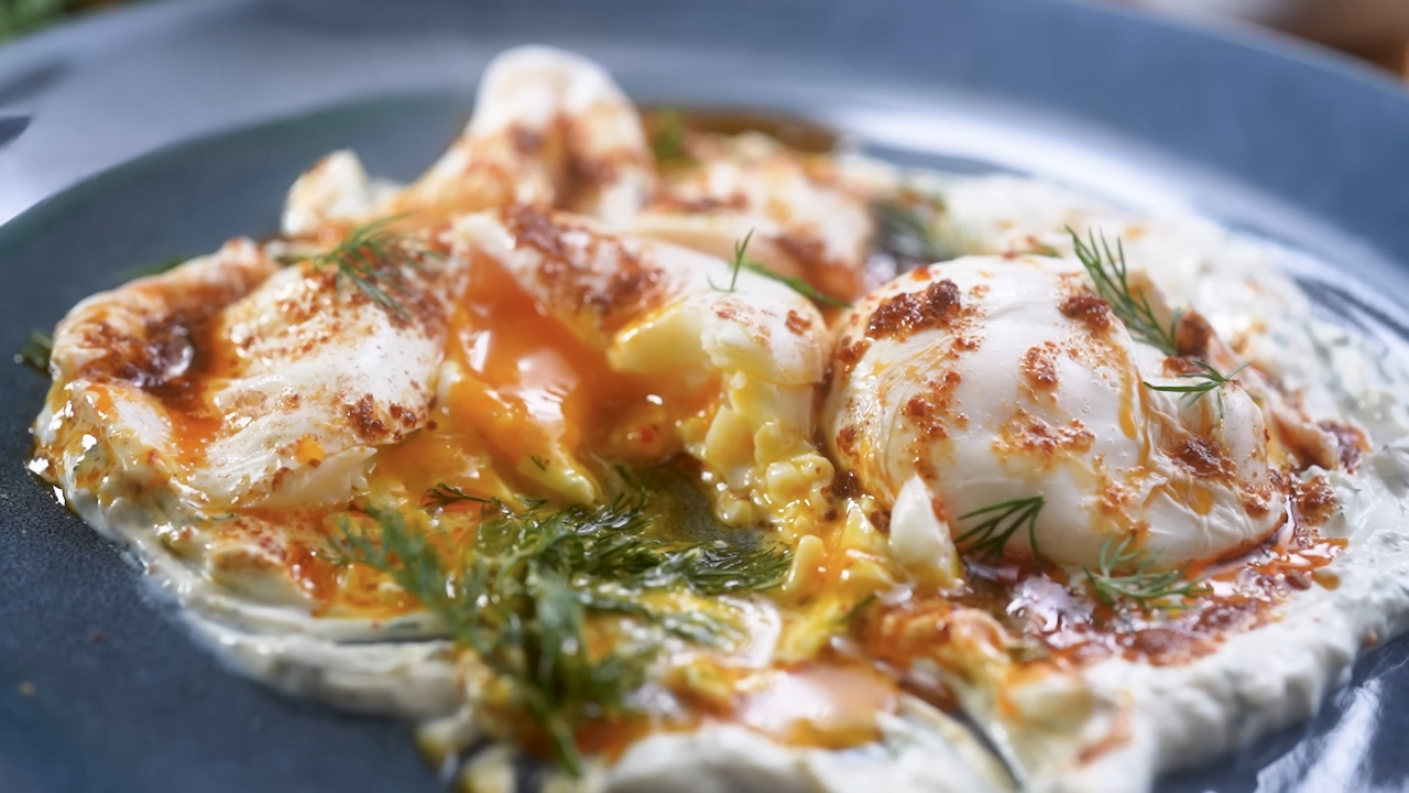 Turkish eggs with poached eggs, garlicky yogurt, chili butter, and fresh dill.